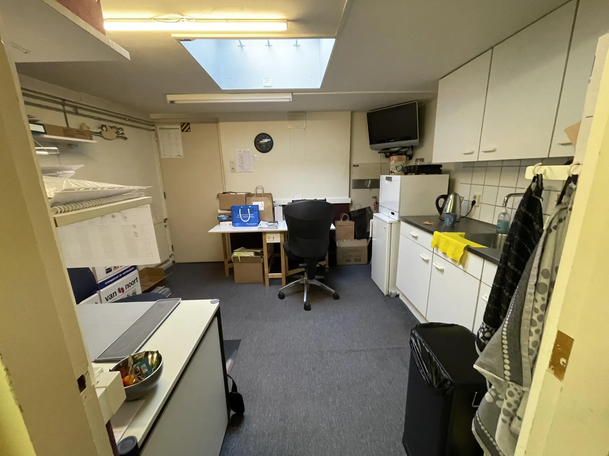 Kleine kantoorruimte aan de Prinses Mariannelaan met bureau, keukenblok en opbergkasten.